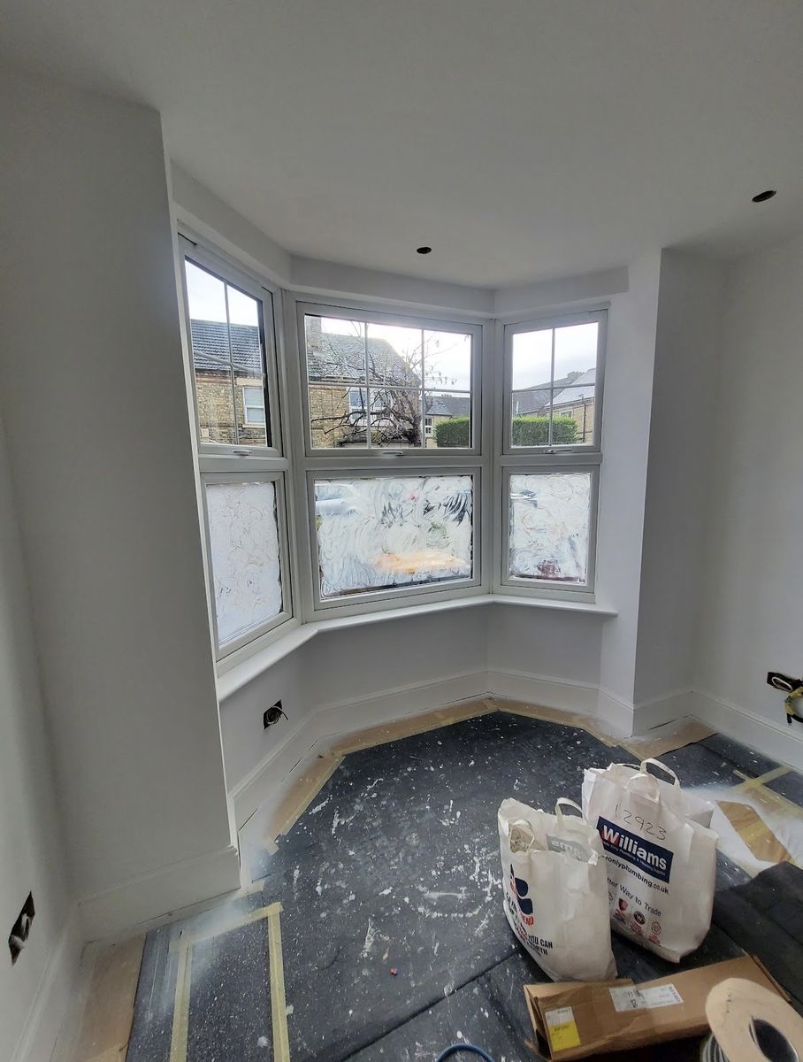 The same bay window finished in white, clean lines around every sash