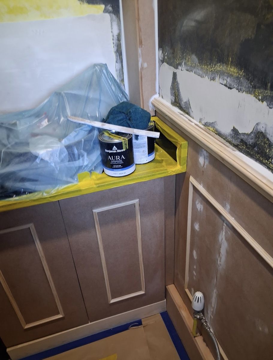 A wall stripped back with panelling primed and the edges masked off