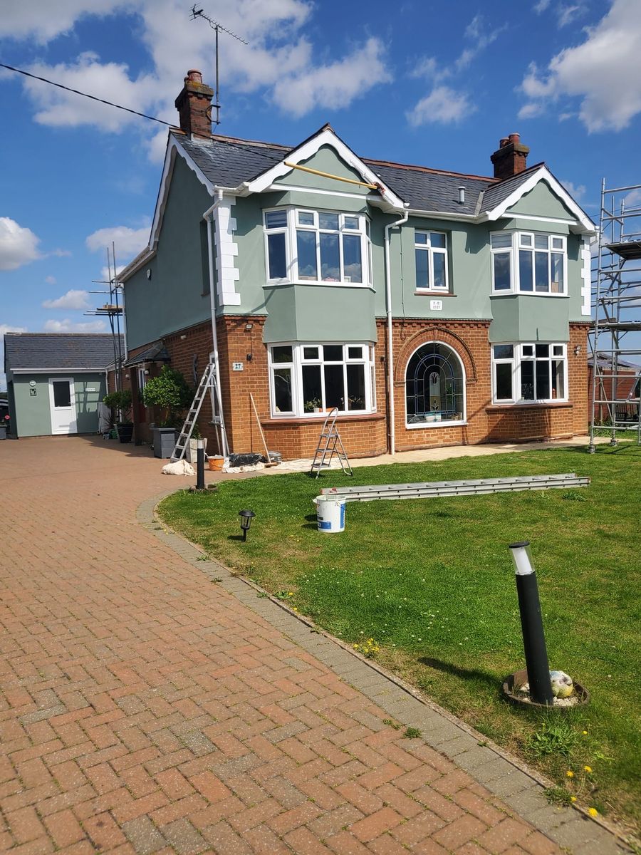 The same front elevation finished in sage green with crisp white bargeboards and window surrounds