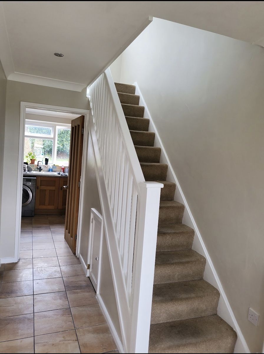 The same hallway finished, with cream walls and crisp white staircase and panelling
