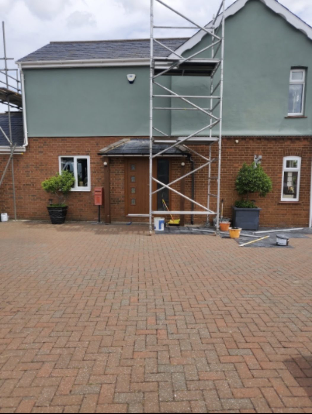 The same house with the render fully repainted in sage green